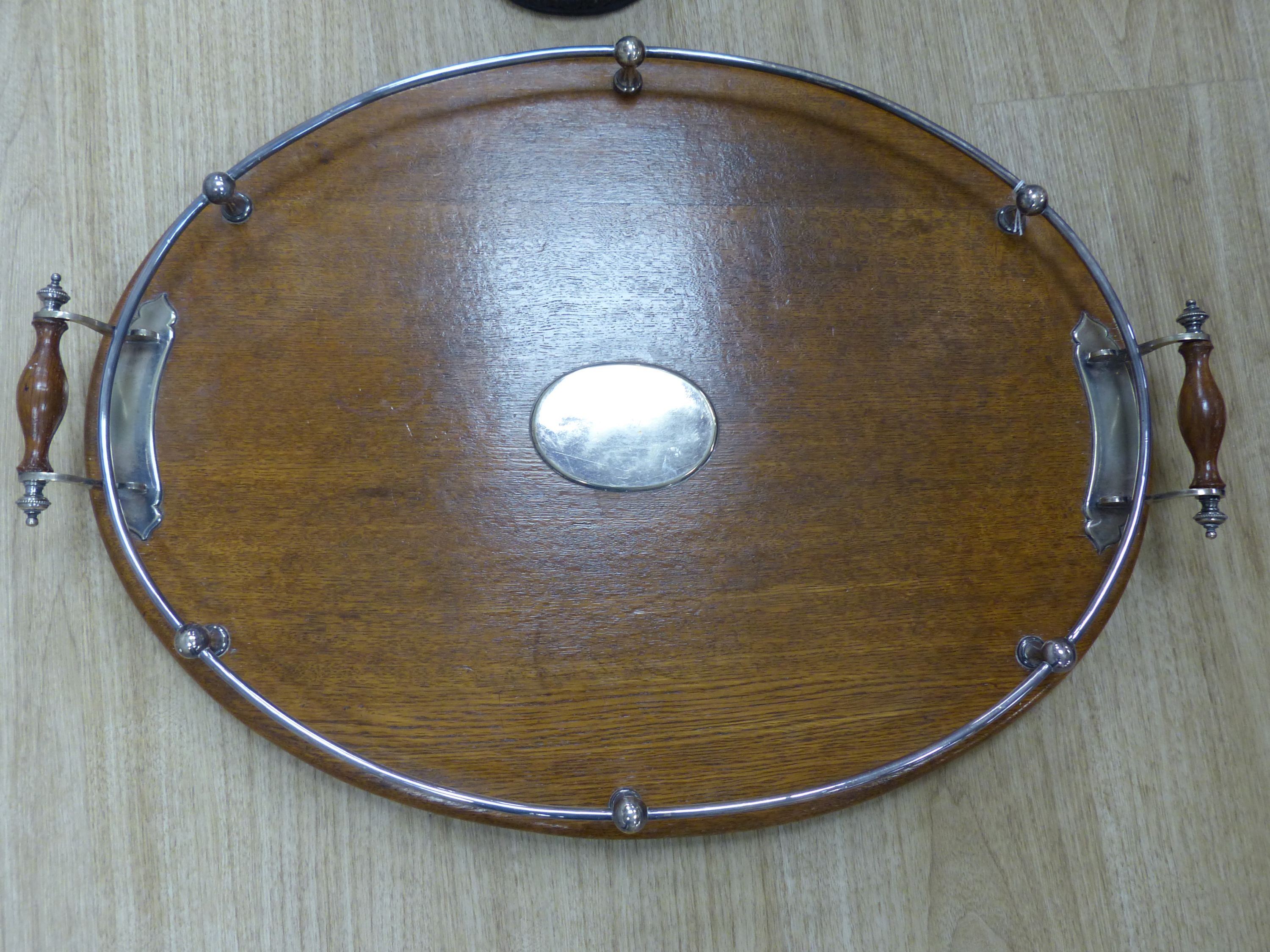 A two handled mahogany oval tray with plated gallery and cartouche and a cast iron door stop